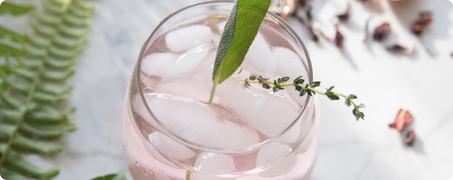 Pink botanical drink on a marble counter.