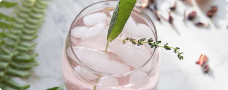 Pink botanical drink on a marble counter.